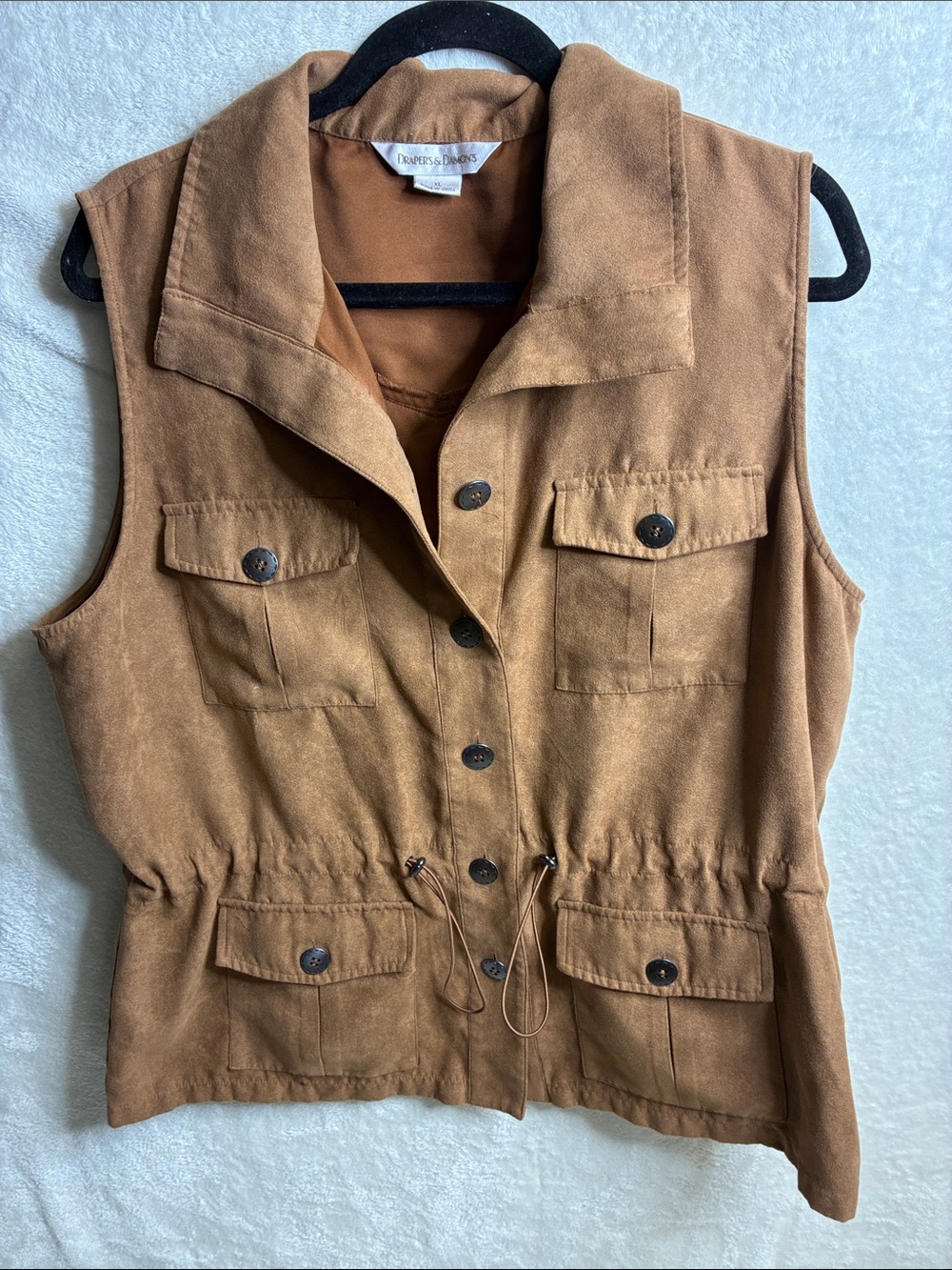 Draper and Damond’s tan sleeveless utility vest